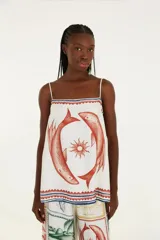 Top blanco con estampado de dos peces rojos y un sol en el centro. Tiene tirantes finos y corte holgado.