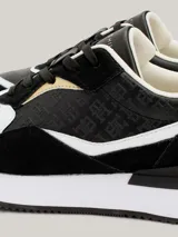 Zapatillas deportivas Tommy Hilfiger de piel negra con paneles con monogramas TH en relieve y detalles en blanco y dorado.