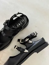 Ballerinas de cuero color marrón con punta fina y dos tiras con hebillas.