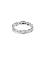 Anillo plateado de metal con forma irregular y textura martillada.