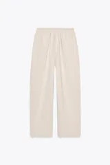 Pantalón ancho color beige, de tiro medio y cintura ajustable con cordones.