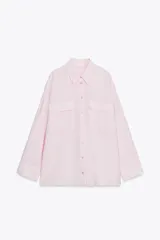 Camisa rosa claro confeccionada en hilatura con modal, de corte holgado, con cuello solapa, manga larga terminada en puño, dos bolsillos con solapa en el delantero y cierre frontal con botones.