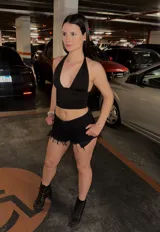 Short de jean negro, tiro alto, con roturas y terminación deshilachada en el ruedo.