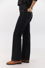 Pantalón de jean negro de corte recto con costuras en color ocre.