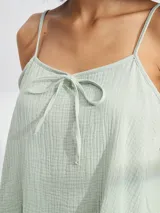 Musculosa color amarillo pálido con tirantes finos y detalle de lazo en el escote.