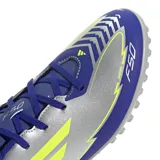 Championes de fútbol 5 Adidas F50 Club TF Messi, color gris con detalles en azul y amarillo. Inspirados en Lionel Messi, diseñados para brindar velocidad, precisión y estabilidad en canchas de césped sintético.