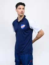 Remera polo de hombre con mangas cortas y cuello clásico. Diseño en color azul con mangas blancas y escudo del Club Nacional de Football bordado en el pecho.