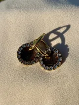 Par de aros dorados con dije circular de resina color terracota con glitter y borde de strass.