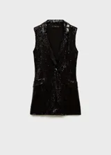 Mono corto negro con lentejuelas, cuello con solapa, sin mangas y bolsillos de ribete.