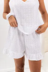 Pijama de algodón blanco con bordado calado, compuesto por musculosa con escote en V y short con cintura elástica y volados.