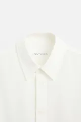 Camisa azul marino de algodón con textura jacquard, corte relaxed fit, cuello solapa, manga larga con puños abotonados y cierre frontal con botones.