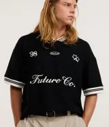 Remera deportiva oversized negra de mangas cortas, confeccionada en algodón texturizado. Posee patch, bordados con raya contrastante y cuello en V con rayas blancas. Estampa frontal con el número 98, la palabra Absolute, dos estrellas y la frase Future Co.