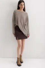 Sweater color crema de viscosa, poliéster, elastano y lurex, de corte holgado y mangas largas.