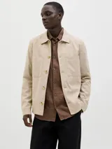 Blazer color beige de lino y algodón, corte slim fit, con solapa clásica, cierre con botón, bolsillo en el pecho y tejido plano resistente.