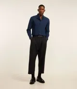 Camisa celeste de corte regular, confeccionada en tejido Oxford de algodón. Tiene cuello inglés, mangas largas y cierre frontal abotonado.