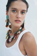 Aros colgantes metálicos con piezas de resina de colores en forma de gota. Cierre con tuerca y clip.