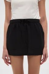 Minifalda negra de algodón con cintura elástica y bolsillos frontales.