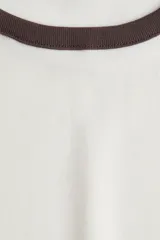 Remera blanca entallada de punto suave con cuello y mangas con ribete marrón.