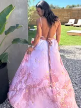 Vestido largo de tela fluida, color verde esmeralda con estampado abstracto en tonos turquesa y detalles dorados. Diseño asimétrico con un solo tirante tejido en el hombro.