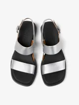 Sandalias plateadas de cuero vacuno con dos tiras anchas sobre el empeine, tira trasera con hebilla ajustable y suela negra con pequeño taco cuadrado.