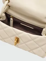 Bolso de hombro pequeño de cuero acolchado color beige claro, con diseño de rombos y cierre giratorio metálico dorado. Posee correa fina para llevar al hombro.