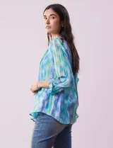 Blusa de gasa estampada, marca Ruby Rd. Cuello a la base, escote en V y abertura central con botones. Delantera con plisados. Largo de manga regulable con presilla y botón.