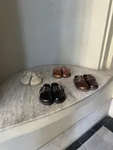 Zuecos de cuero con hebilla y tachas.