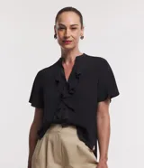 Camisa de chiffon negra con cuello en V, volado delantero y manga corta.