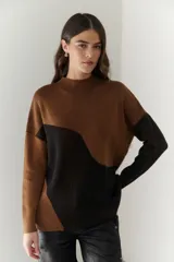Buzo de punto con diseño geométrico en bloques de color gris y negro, de cuello redondo y mangas largas.