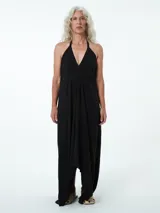 Vestido largo negro con escote en V, caída asimétrica en picos y espalda baja.