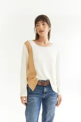 Remera de algodón color blanco con manga larga, corte irregular y franja lateral color beige.