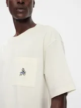 Remera azul marino de corte holgado con bolsillo en el pecho y bordado de Mickey Mouse.