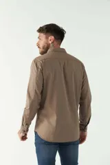 Camisa de hombre color marrón con efecto stone wash, fit regular, cuello americano, cierre con botones, dos bolsillos frontales con botón y mangas largas con puños abotonados.