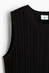 Musculosa negra de punto acanalado, con corte ajustado y ribete acanalado fino en escote, sisas y bajo.