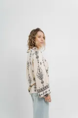 Camisa beige con estampado boho en negro, corte relajado, mangas largas con puño elástico y botones frontales.