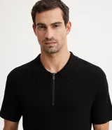 Polo de hombre color negro, de corte regular, manga corta y cuello camisero con cremallera.