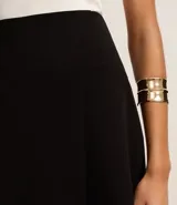 Short pollera negro confeccionado en crepé con traspase envolvente.