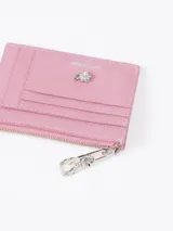 Tarjetero de cuero vacuno color bordó con aplique metálico de flor y tiracierre con diseño exclusivo.