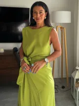 Vestido largo color verde lima, sin mangas y con escote redondo. Presenta un detalle de lazo ajustable a la altura de la cintura.