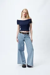 Top tejido color blanco con escote bardot que deja los hombros al descubierto y punto acanalado.