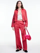 Campera corta de denim color rojo con textura metalizada, cuello camisero, cierre frontal con botones a presión, bolsillos de parche en el pecho y ruedo desflecado.