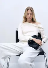 Blusa color crudo de tejido satinado, con cuello drapeado, mangas largas con puños abiertos y corte recto. Ideal para eventos formales.