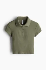 Remera polo verde oliva en punto de algodón acanalado, de manga corta con cuello clásico y tapeta de botones. Corte entallado.