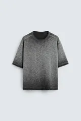 Camiseta gris de punto con efecto lavado, corte holgado, cuello redondo y mangas cortas.