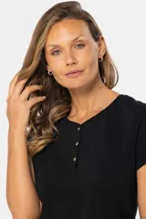 Remera color rosa viejo de corte clásico, con cuello redondo y tapeta con tres botones.