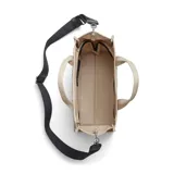 Tote bag de lona color beige con la inscripción "THE TOTE BAG MARC JACOBS" en el frente. Incluye cierre de cremallera, asas superiores y una correa de hombro ajustable y extraíble de color negro.