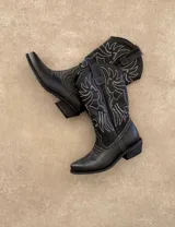 Botas de cuero negro con bordado decorativo en el caño y empeine, taco bajo y punta fina. Diseño de estilo cowboy.