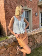 Musculosa tejida en látex metálico, con escote en V tanto en el frente como en la espalda, y detalle deshilachado en el frente.