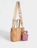 Cartera tipo tote color beige, de tela deportiva, con doble asa corta y correa larga regulable y desmontable. Tiene un bolsillo lateral con forma de pouch.