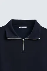 Sudadera azul marino de cuello alto con cierre frontal de cremallera, corte relaxed fit, manga larga y terminaciones en rib.